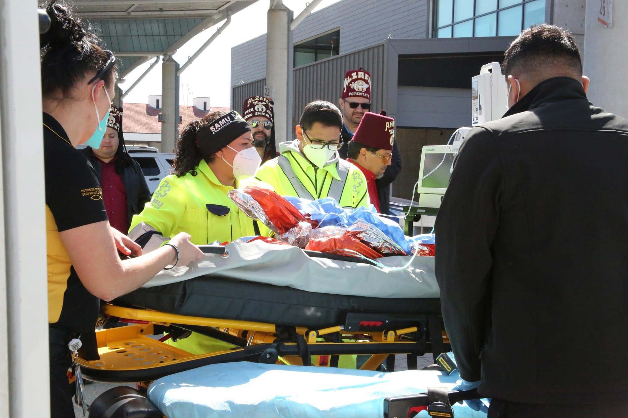 medical personnel, Shriners and patient on gurney