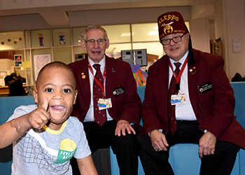 Shriner besuchen einen Patienten im Krankenhaus