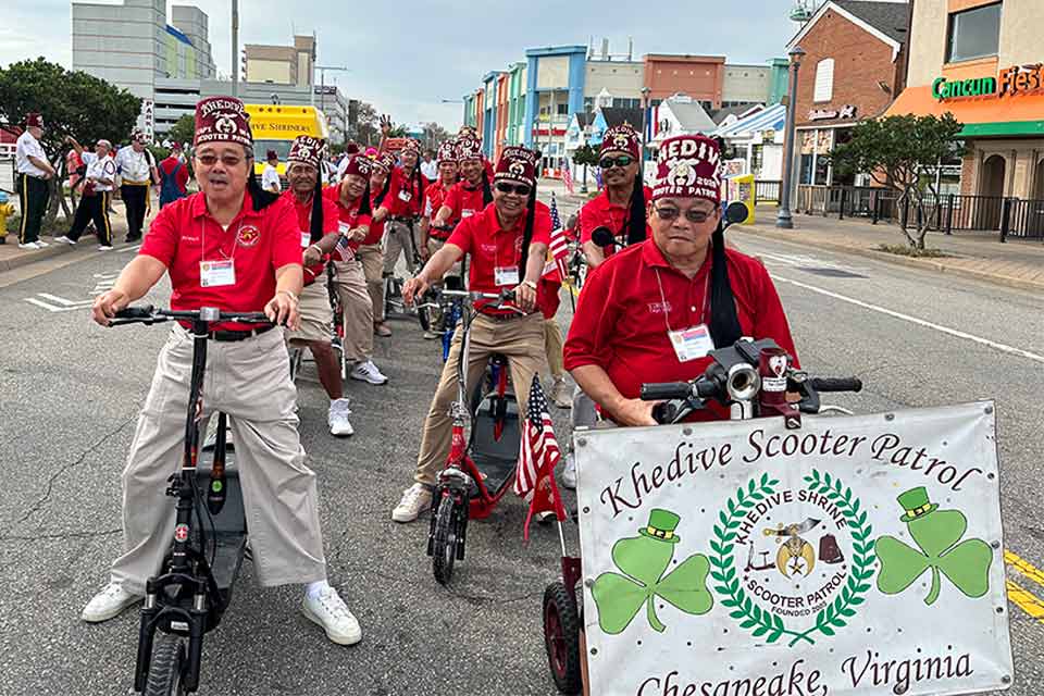 Los Shriners del Khedive viajando en scooters en un desfile