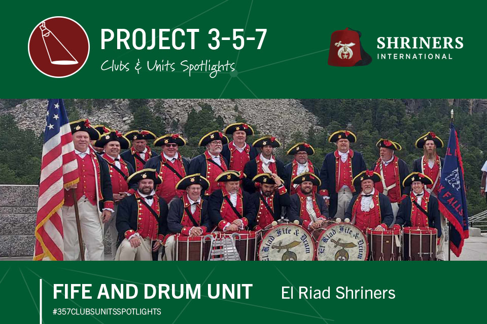 Projeto 3-5-7 Clubes e Unidades em Destaque; Unidade Fife e Drum, El Riad Shriners, #357clubsunitsspotlights; Logotipo da Shriners International; 18 homens vestidos com trajes coloniais segurando tambores.