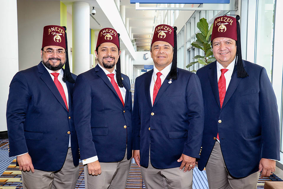four shriners in blue sport coats posing together