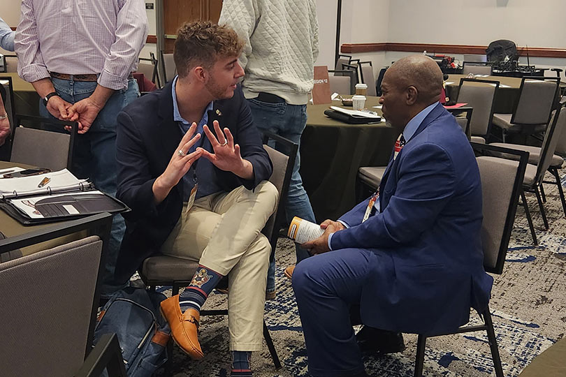 Dois homens discutindo na mesa de conferência