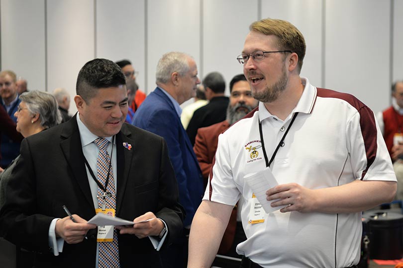 Dois homens em pé e conversando