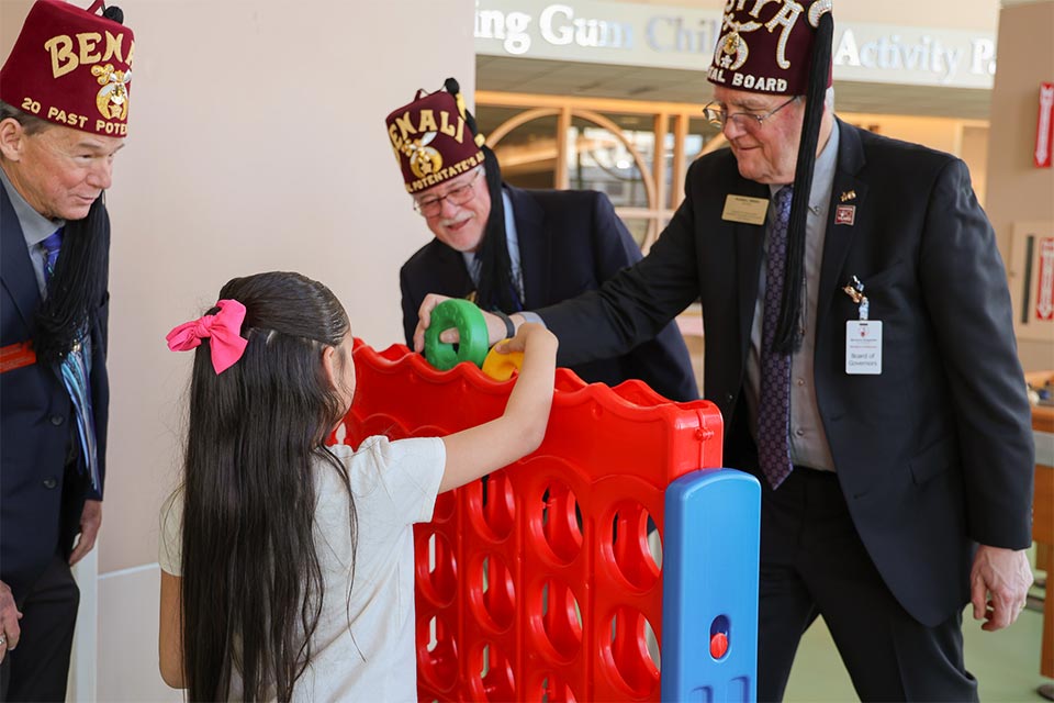 Shriners jugando con un paciente del Shriners Children's