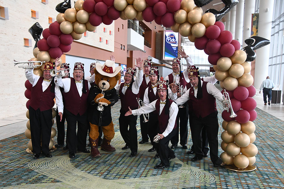 Shriners se divertindo sob o balão do arco-íris