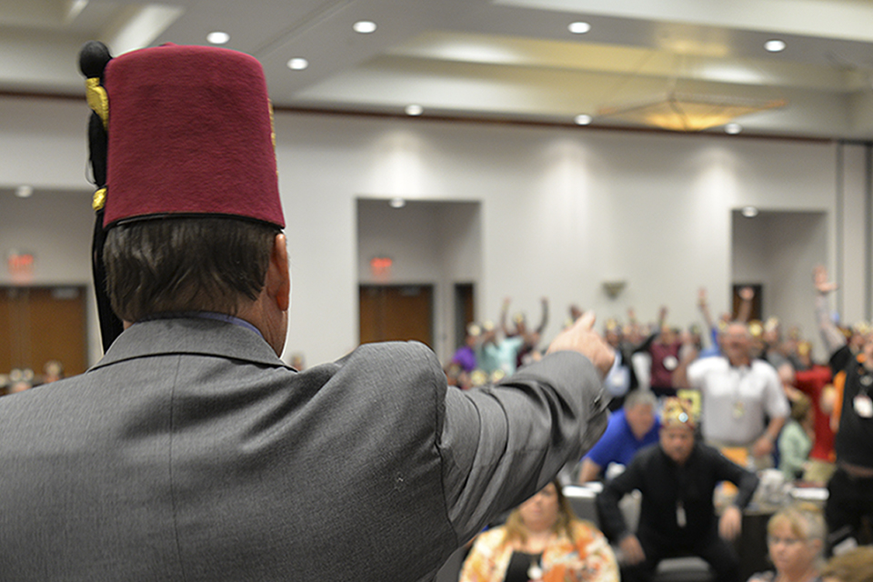 Back of a presenters head speaking to audience at conference