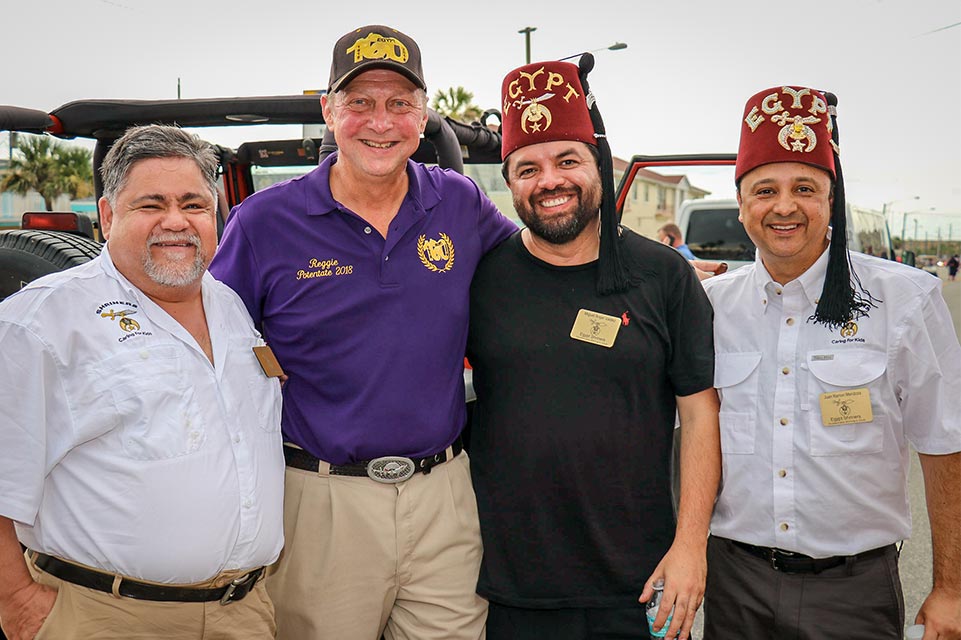 Cuatro Shriners junto a un jeep en el evento de Daytona