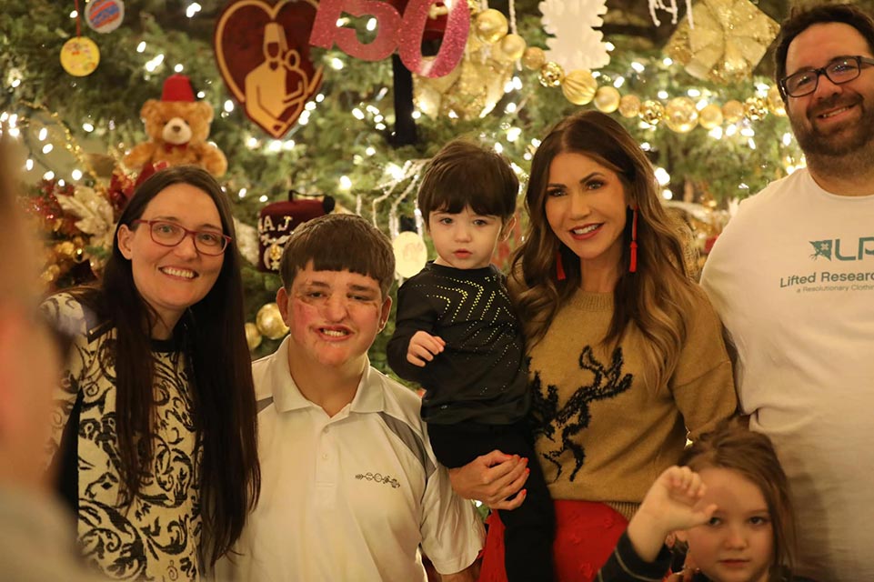 family in front of Christmas tree