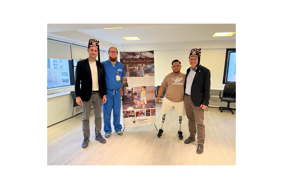 Shriners debout devant une pancarte avec le fournisseur et le patient