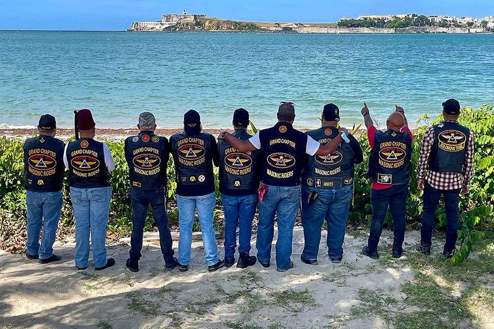 nine Shriners on beach, looking out at the water