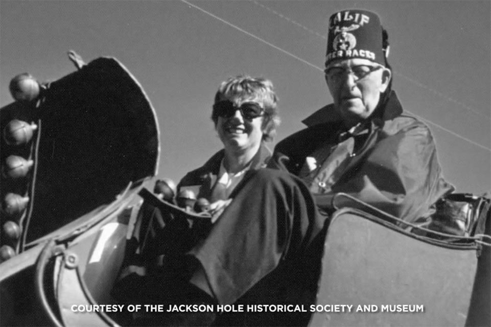 shriner y dama sentada en un trineo cortesía de la sociedad histórica de jackson hole 
