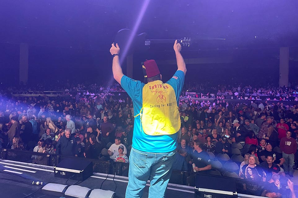 Shriner onstage holding guitar