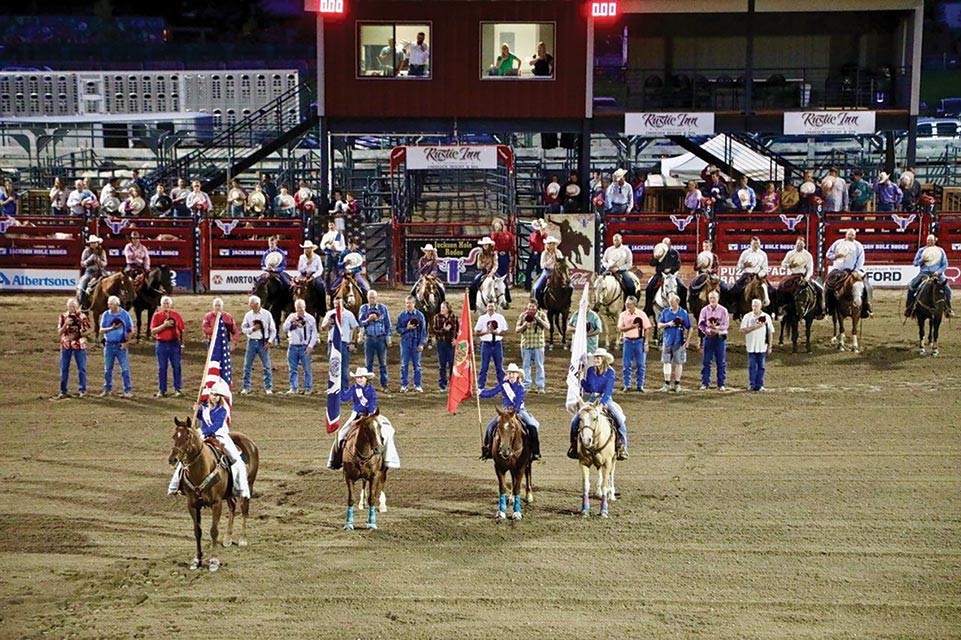 individuals on horses at the rodeo
