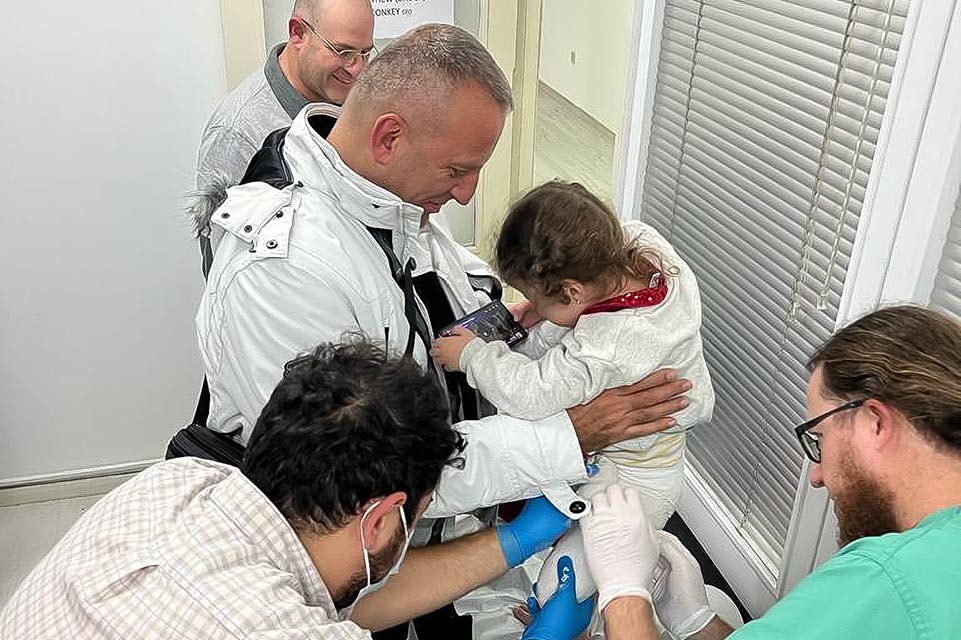 Shriners and staff member working with patient