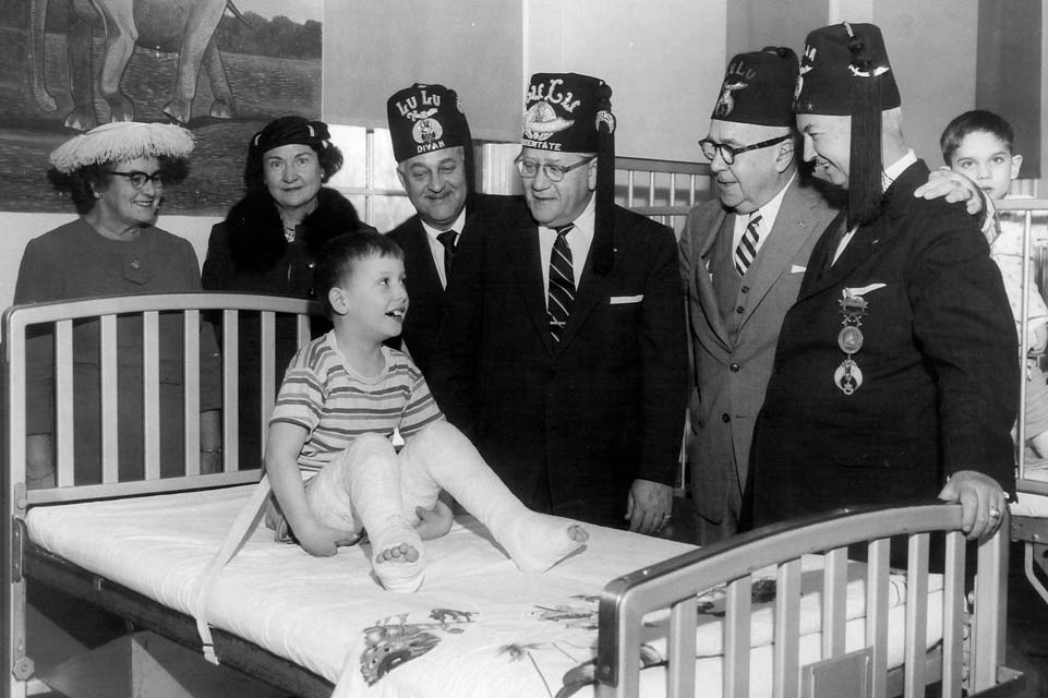 shriners with a patient in black and white