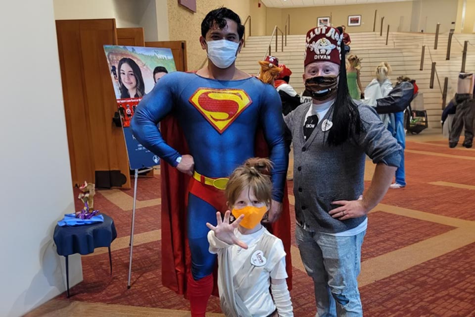 man wearing superman costume, shriner and child