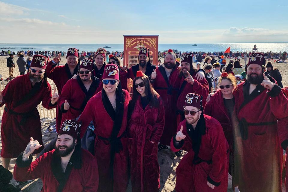 large group of Shriners on beach wearing bathrobes