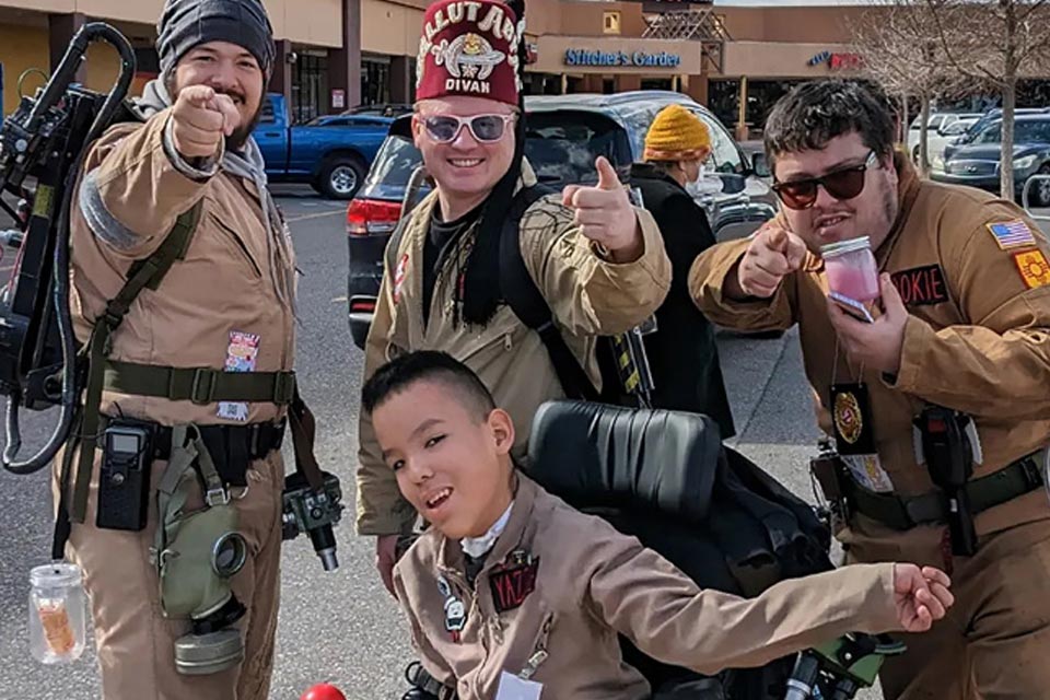 three shriners and patient in wheelchair wearing costumes