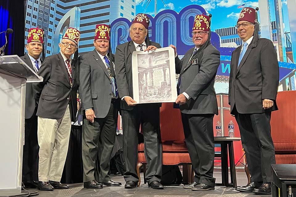 Five members of the Nemity Shriners holding a poster