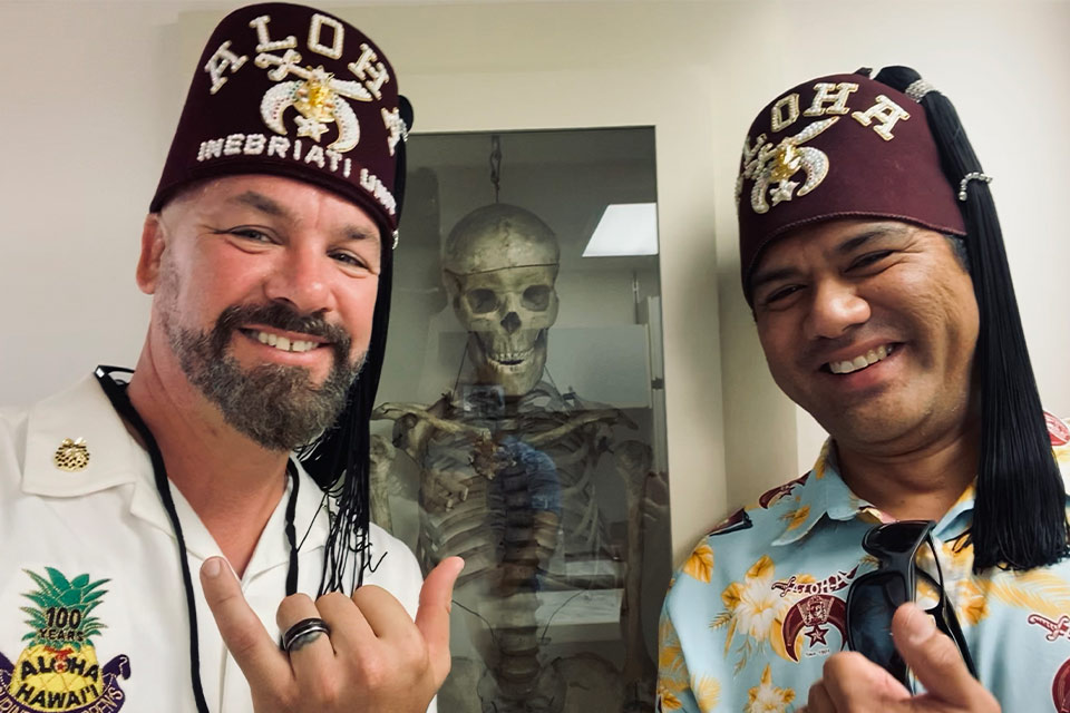 Dois Aloha Shriners em frente a uma exposição de museu.