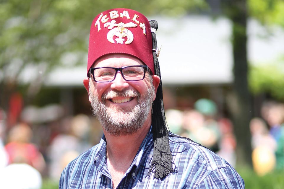 Shriner sonriente con un fez rojo