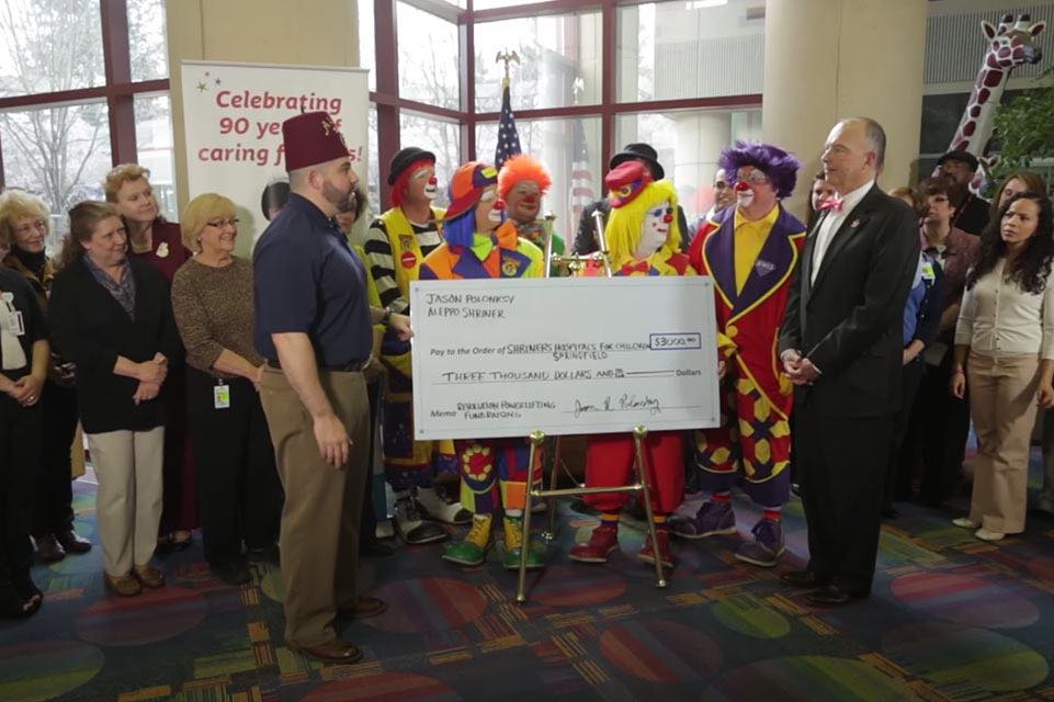 Shriner überreicht Scheck an ein Shriners Hospital for Children